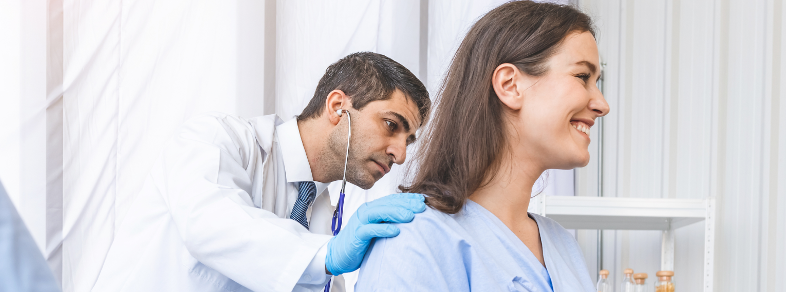 Eine lächelnde Patientin in einer Arztpraxis.