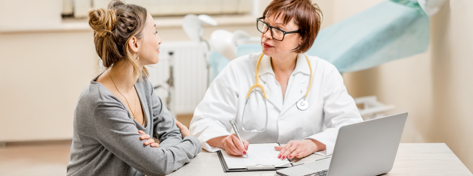 Eine Patientin spricht mit ihrer Ärztin im Untersuchungszimmer.
