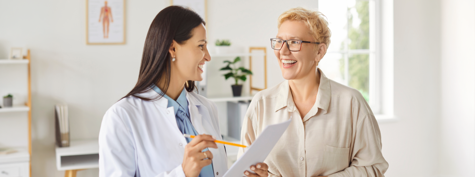 Eine Patientin lächelt, während sie mit ihrer Osteopathin spricht.