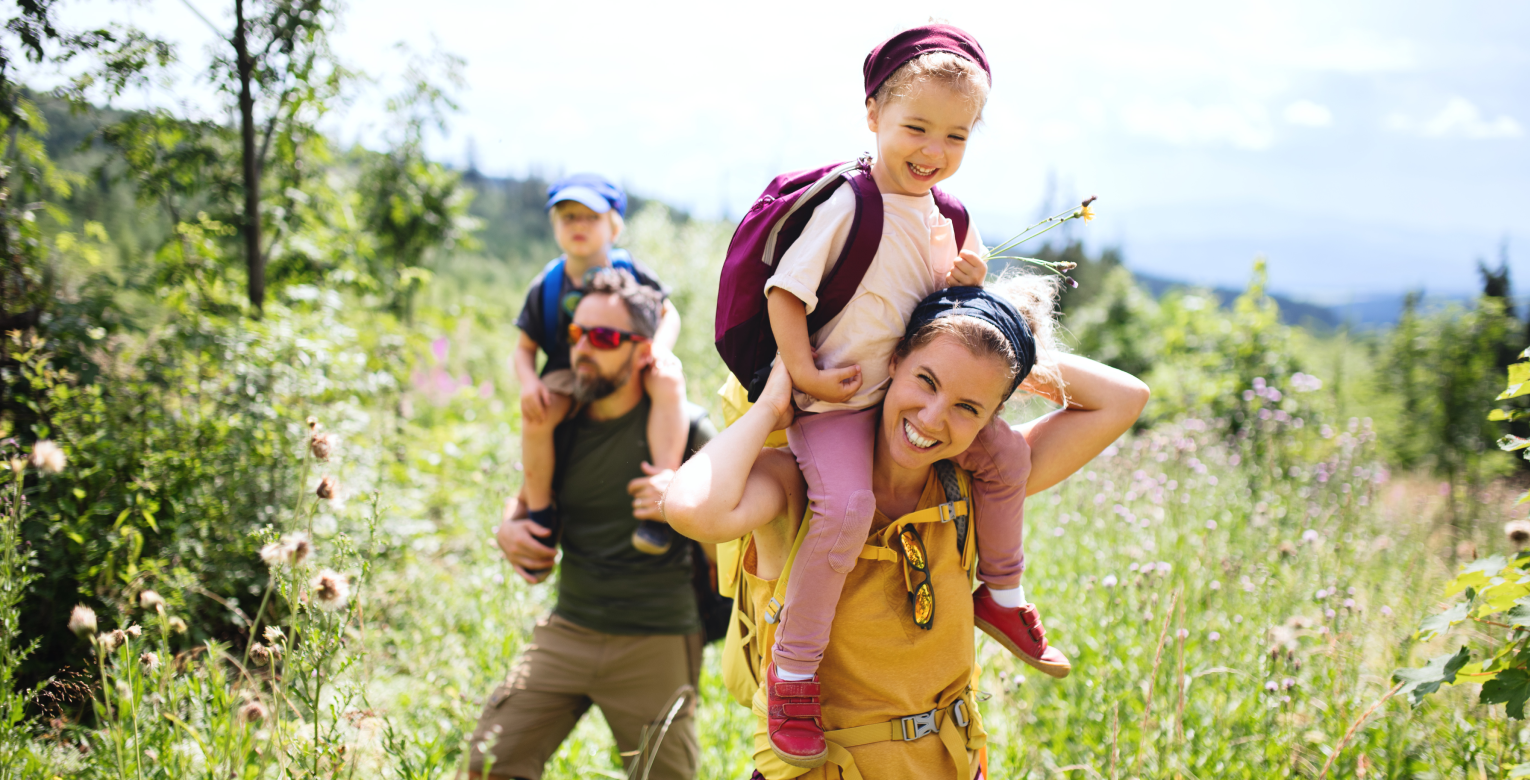 Eine lachende Familie wandert in der Natur.