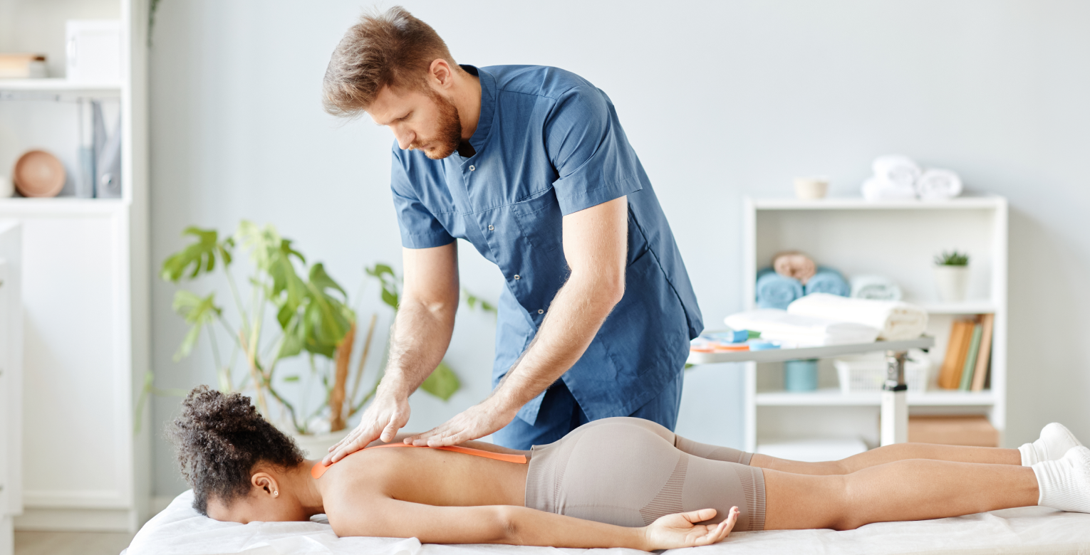 Ein Chiropraktiker behandelt den Rücken einer Patientin.