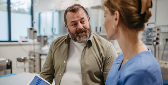 Ein Patient mit ambulanter Zusatzversicherung spricht mit einer Ärztin.